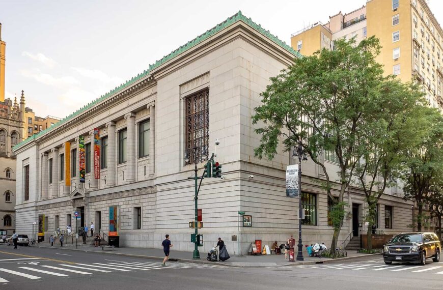 The limestone New-York Historical Society building with a green roofline and exhibition banners on Central Park West