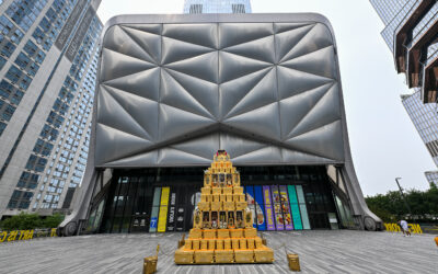 The ridged steel shell of The Shed at Hudson Yards, with a tiered gold sculpture standing on the plaza in front of the entrance
