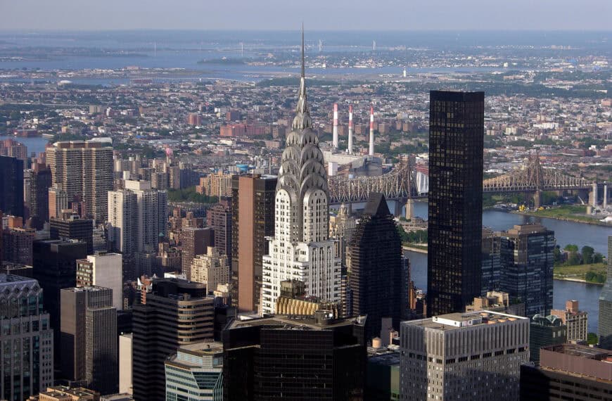 The stainless-steel crown and spire of the Chrysler Building rising above Midtown, with the East River behind