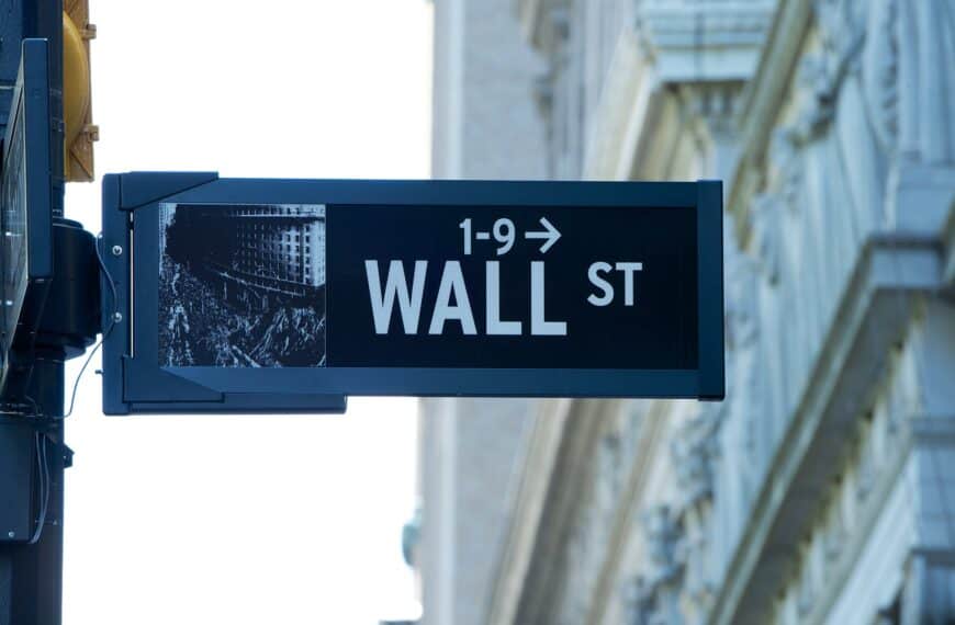 A Wall Street sign for numbers 1 to 9 against the stone facade of a Financial District building